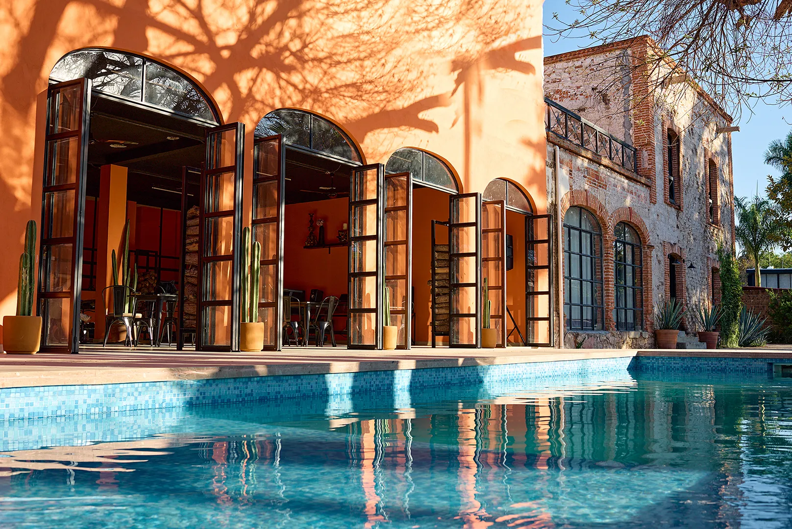 Fachada del hotel Casa Grande Rio con alberca y arcos de medio punto en Rioverde, San Luis Potosí, destacando arquitectura rústica y jardín con cactáceas.