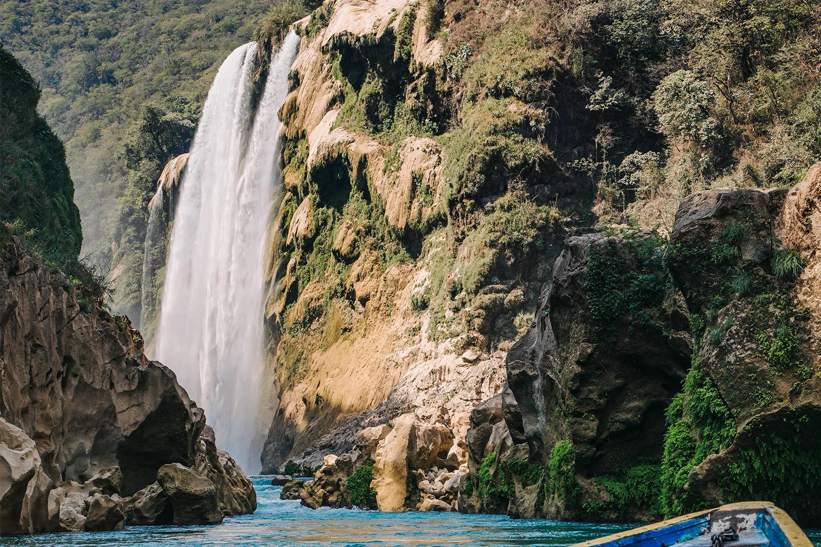 Impresionante vista de la Cascada de Tamul cayendo sobre el río Santa María, capturada desde una panga de madera durante un tour en la Huasteca Potosina, San Luis Potosí.