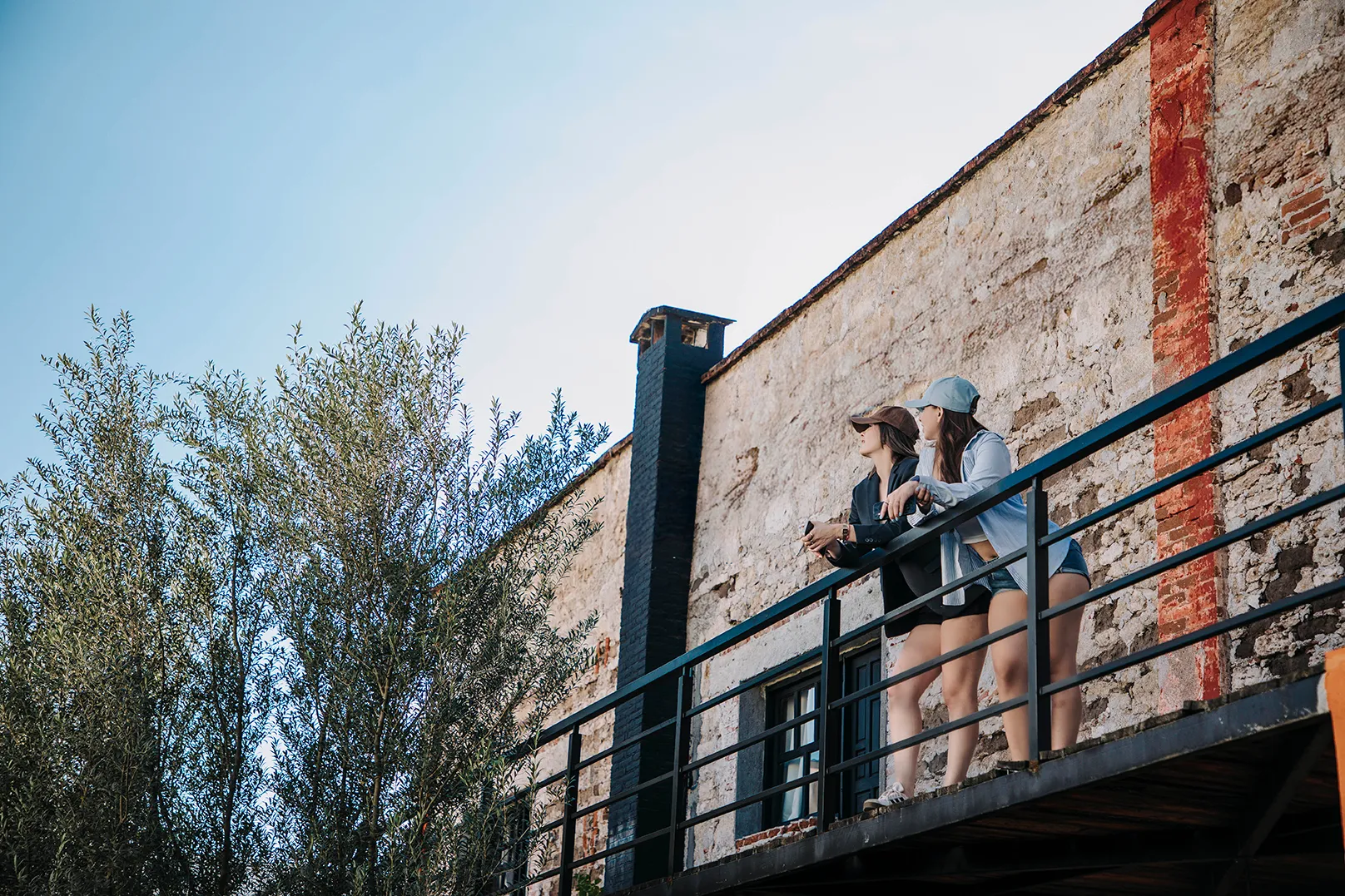 Dos mujeres disfrutando de la vista desde el balcón de una habitación rústica en Casa Grande Rio - hotel boutique de Rioverde, San Luis Potosí, cerca de la Media Luna.